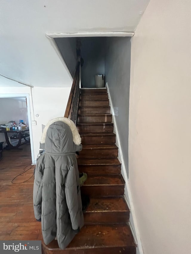 stairway with baseboards and wood finished floors