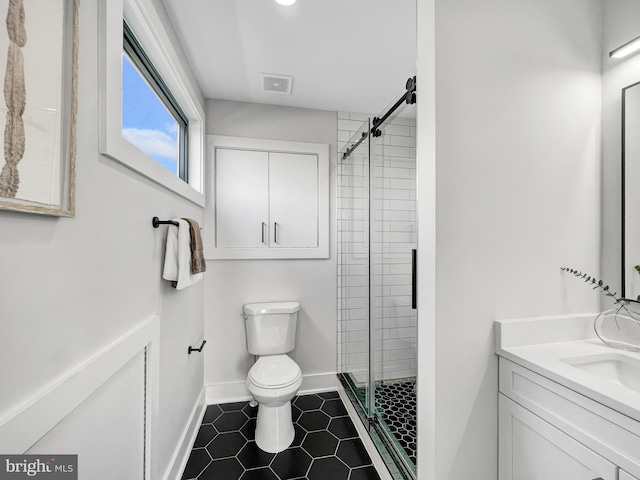 full bath with visible vents, toilet, a stall shower, baseboards, and vanity