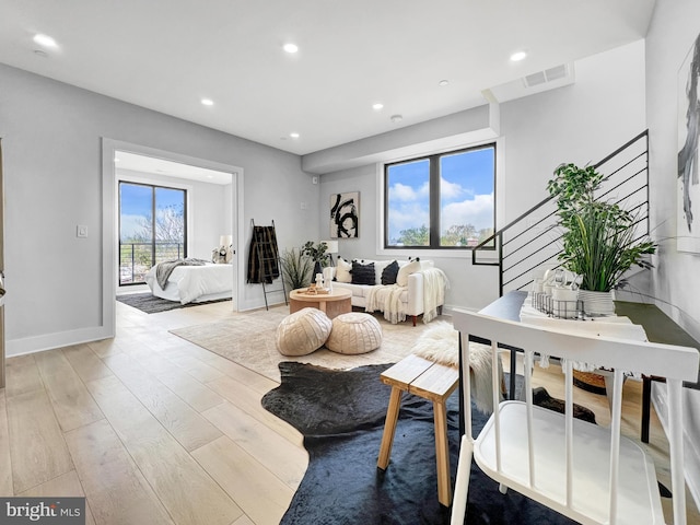 living room with stairway, visible vents, baseboards, recessed lighting, and light wood-type flooring