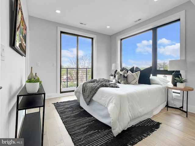 bedroom featuring visible vents, light wood-style flooring, and baseboards