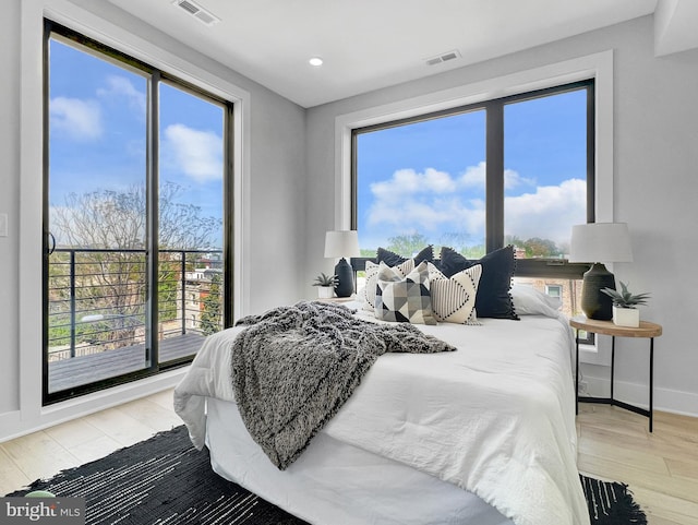 bedroom with visible vents, baseboards, and wood finished floors