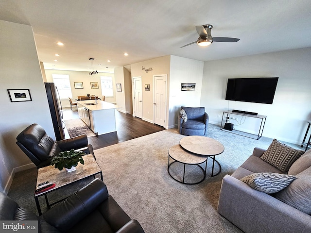 living area featuring a ceiling fan, baseboards, recessed lighting, dark wood-type flooring, and dark carpet