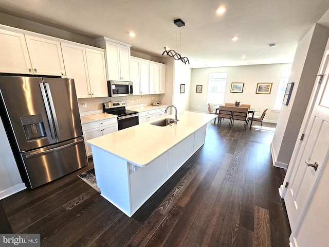 kitchen featuring dark wood-style flooring, a sink, light countertops, white cabinets, and appliances with stainless steel finishes