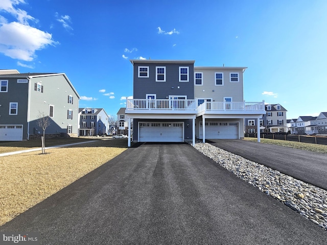 view of front of property featuring aphalt driveway, a residential view, and a garage