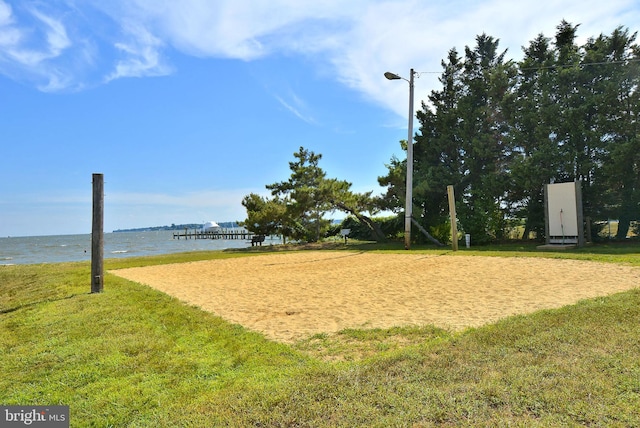 surrounding community featuring volleyball court, a yard, and a water view