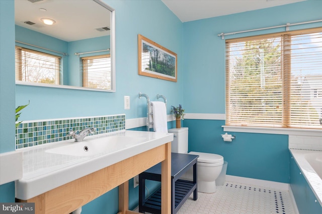 bathroom with visible vents, toilet, tile patterned flooring, and a washtub