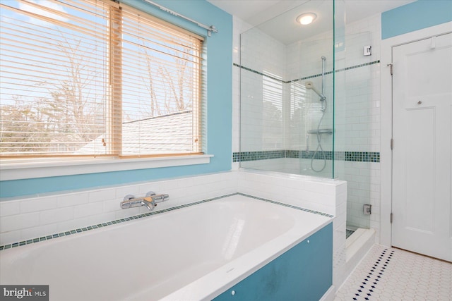 bathroom featuring a bath, plenty of natural light, and a shower stall