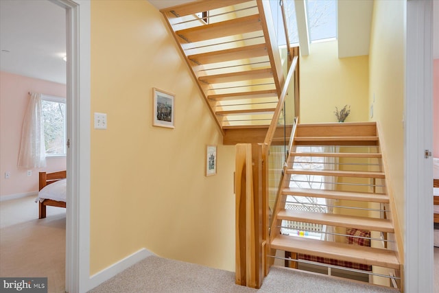 stairway featuring carpet flooring and baseboards