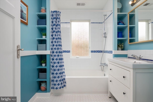 bathroom with visible vents, a healthy amount of sunlight, and shower / tub combo