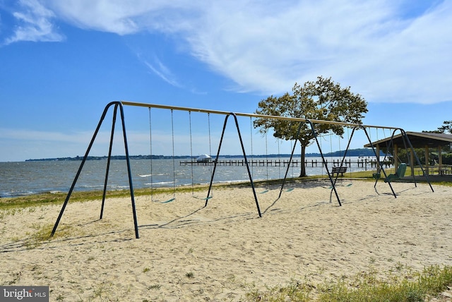 exterior space featuring playground community and a water view