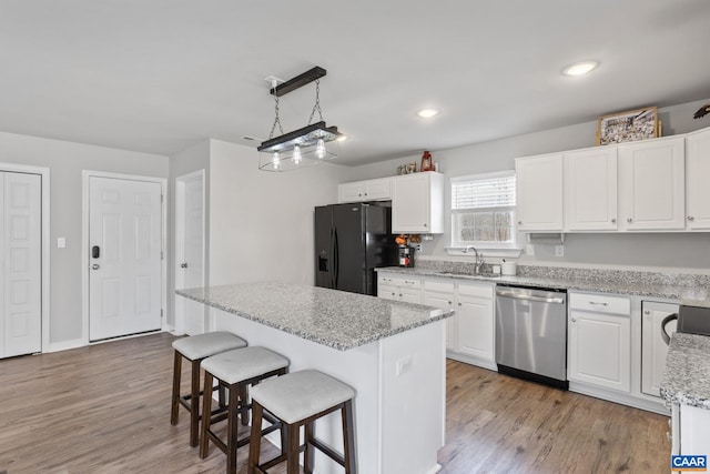 kitchen featuring a kitchen breakfast bar, stainless steel dishwasher, white cabinets, and black fridge with ice dispenser