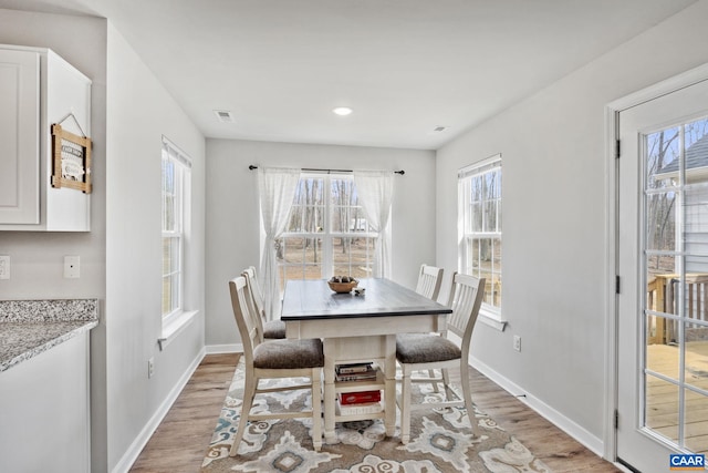 dining room with visible vents, baseboards, and light wood-type flooring