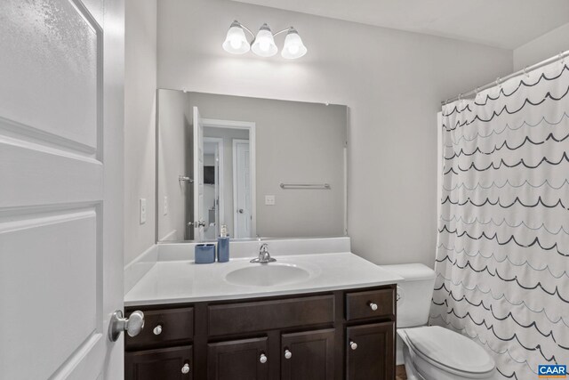 bathroom featuring vanity, a shower with shower curtain, and toilet