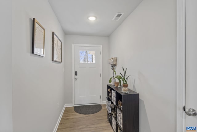 foyer entrance with visible vents, light wood-type flooring, and baseboards