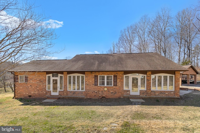 back of property featuring brick siding, a lawn, and a shingled roof