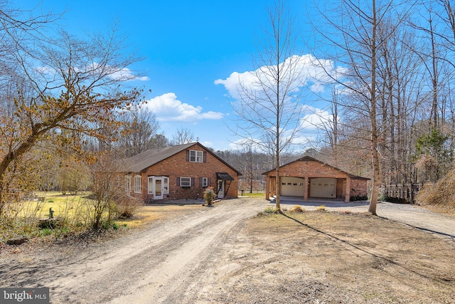 view of front of house with brick siding, driveway, and an outdoor structure