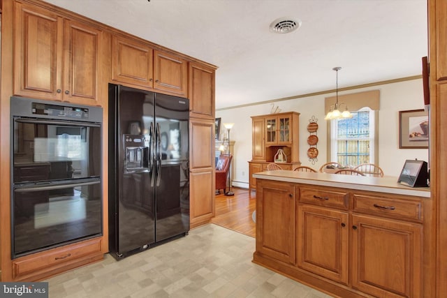 kitchen featuring visible vents, crown molding, a peninsula, brown cabinetry, and black appliances