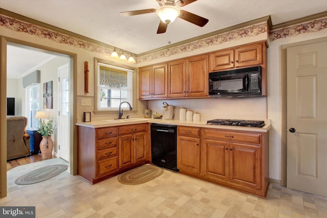 kitchen featuring black appliances, light countertops, brown cabinets, and a sink