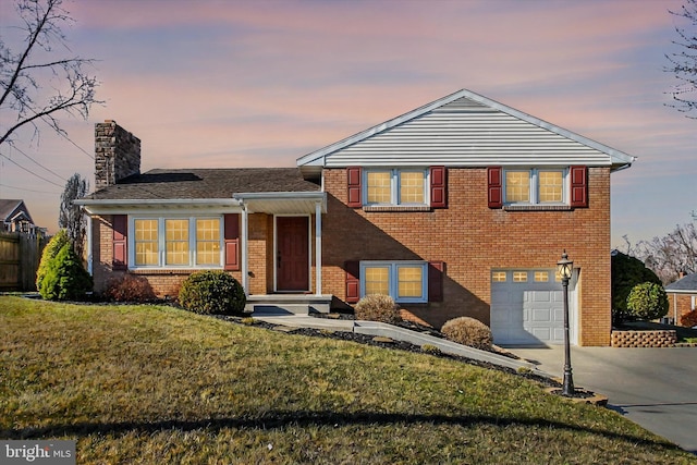 tri-level home featuring brick siding, driveway, and a garage