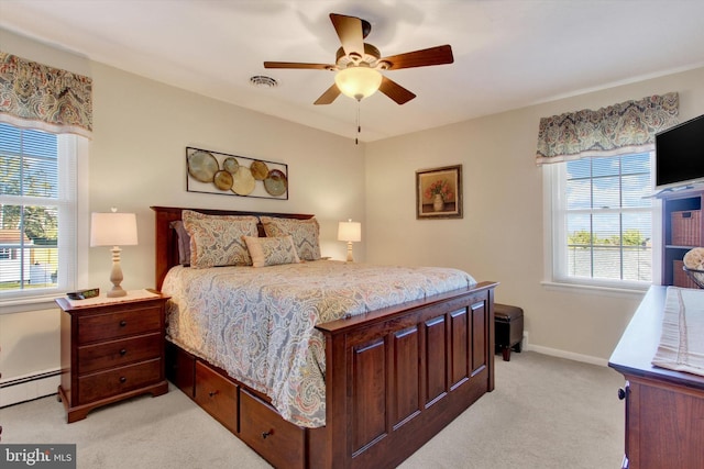 bedroom with visible vents, baseboards, light carpet, baseboard heating, and a ceiling fan