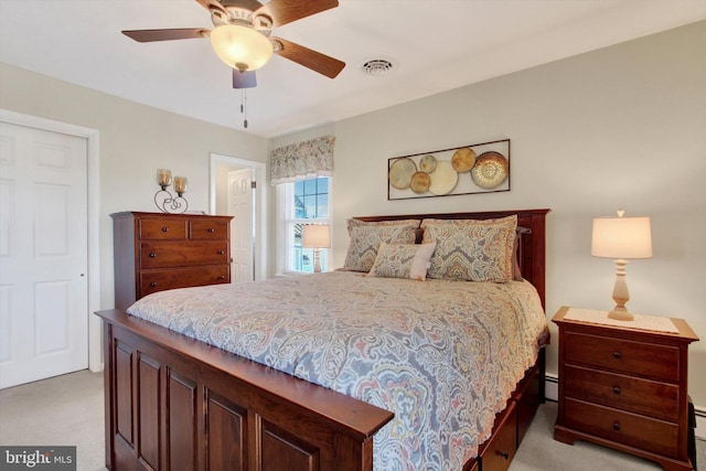 bedroom with visible vents, light carpet, a baseboard heating unit, and a ceiling fan