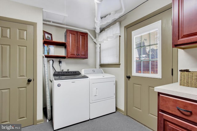 clothes washing area featuring separate washer and dryer, attic access, and cabinet space