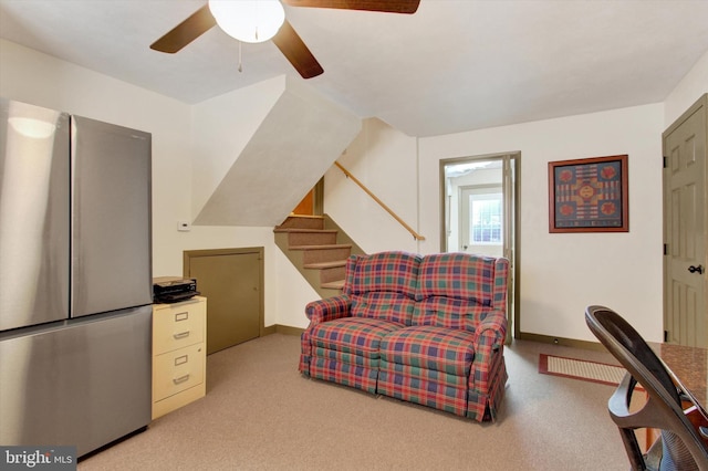 living area featuring baseboards, ceiling fan, and carpet flooring