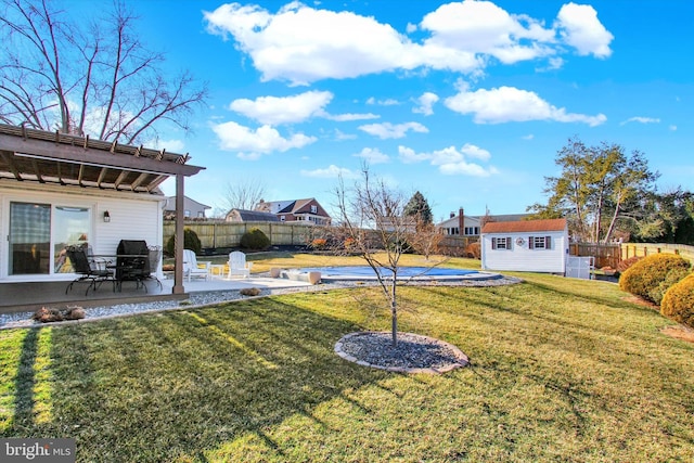 view of yard with an outbuilding, a fenced backyard, a pergola, and a patio area