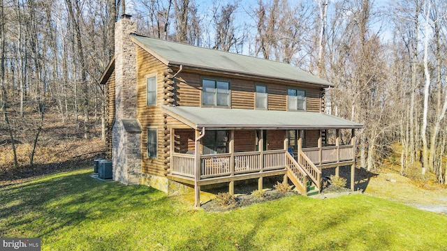 log cabin featuring log siding, central AC, a chimney, and a front lawn