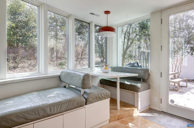 sunroom featuring visible vents and plenty of natural light