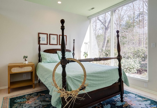 bedroom with a wall of windows, multiple windows, baseboards, and visible vents