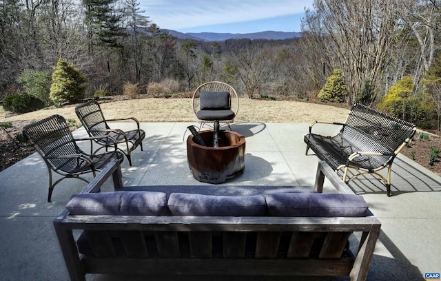 view of patio featuring a mountain view and a forest view