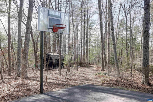 view of sport court with a forest view and basketball court