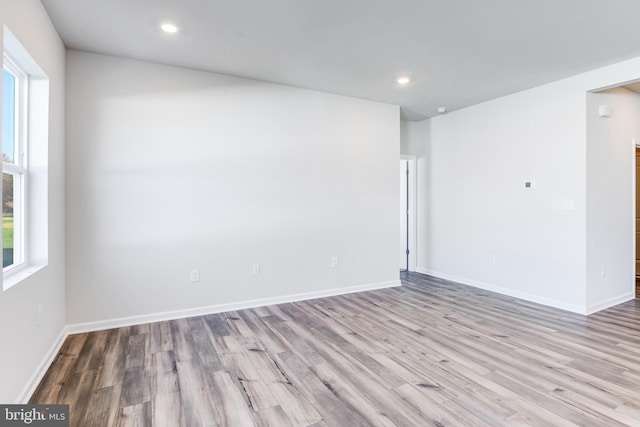 spare room with recessed lighting, wood finished floors, and baseboards