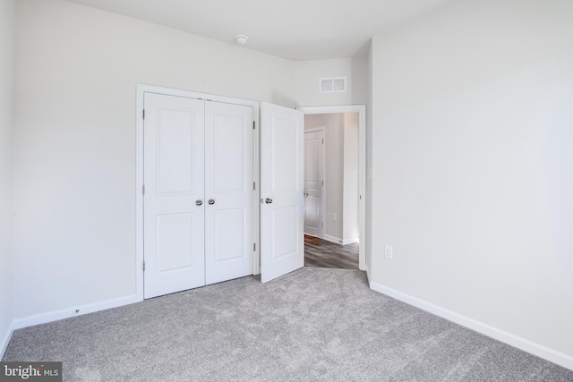 unfurnished bedroom featuring visible vents, baseboards, a closet, and carpet flooring