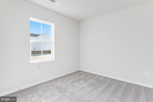 carpeted empty room featuring baseboards and visible vents