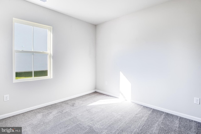 carpeted spare room with baseboards