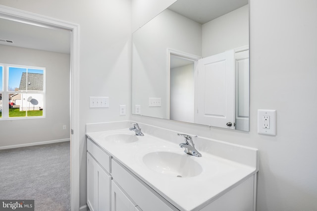 bathroom featuring double vanity, visible vents, baseboards, and a sink