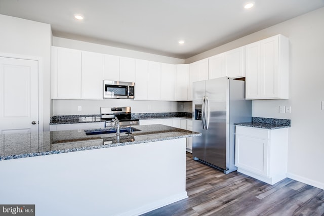 kitchen featuring a sink, dark stone counters, and stainless steel appliances