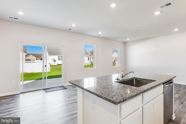 kitchen with visible vents, stainless steel dishwasher, light wood-style floors, and a sink