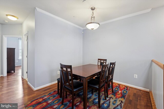dining room with crown molding, baseboards, and wood finished floors