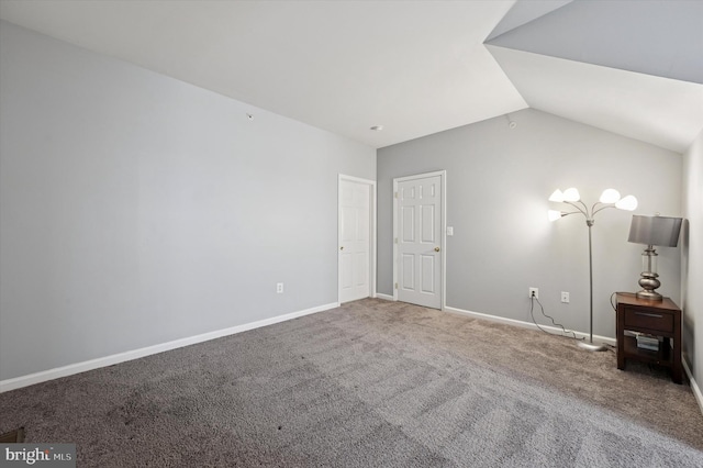 unfurnished bedroom with carpet floors, baseboards, and lofted ceiling