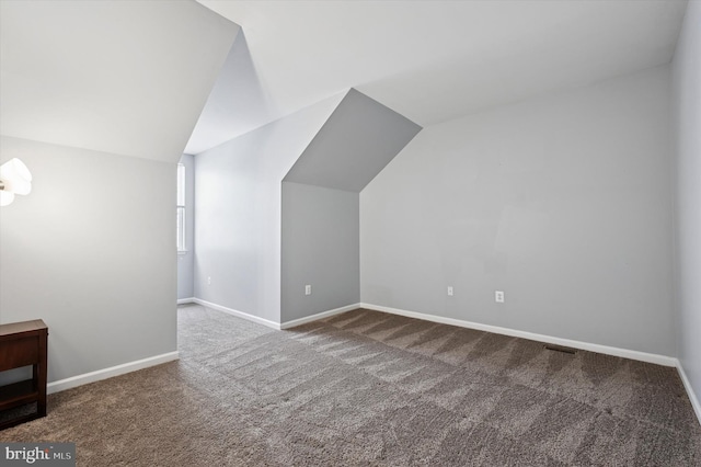 bonus room with carpet flooring, baseboards, visible vents, and lofted ceiling