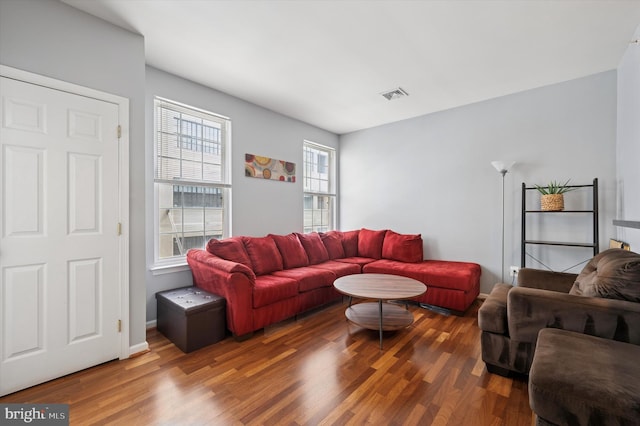 living area with visible vents and wood finished floors