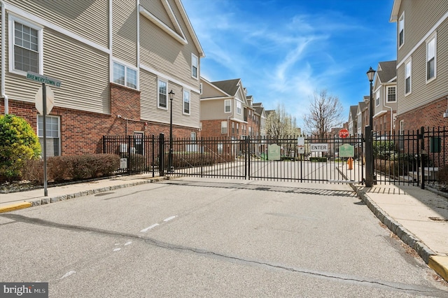 view of road featuring a residential view, sidewalks, traffic signs, and curbs