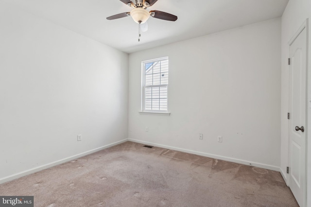 spare room featuring baseboards, carpet floors, visible vents, and a ceiling fan