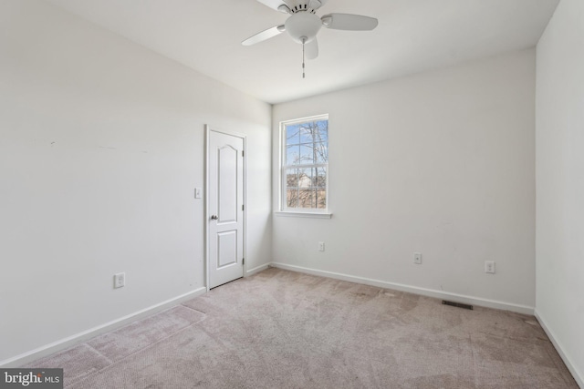 spare room featuring a ceiling fan, carpet flooring, baseboards, and visible vents