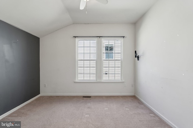 unfurnished room featuring baseboards, light carpet, lofted ceiling, and a ceiling fan