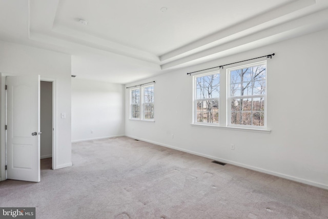 unfurnished bedroom with visible vents, baseboards, a raised ceiling, and carpet