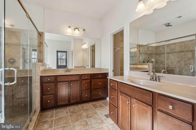 bathroom with tile patterned flooring, a stall shower, and a sink